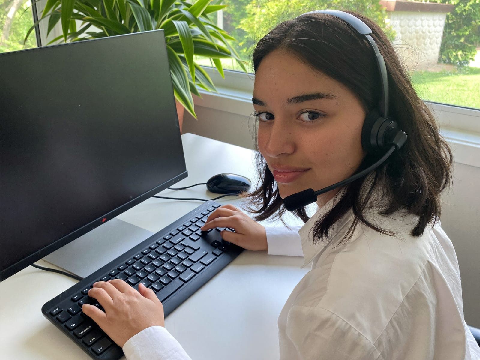 Customer support specialist working at a bright desk with a headset