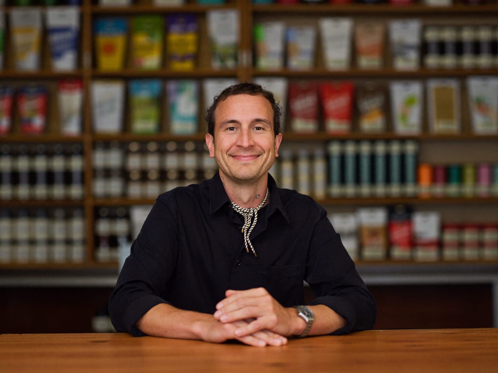 Small business owner standing behind the counter of an independent shop